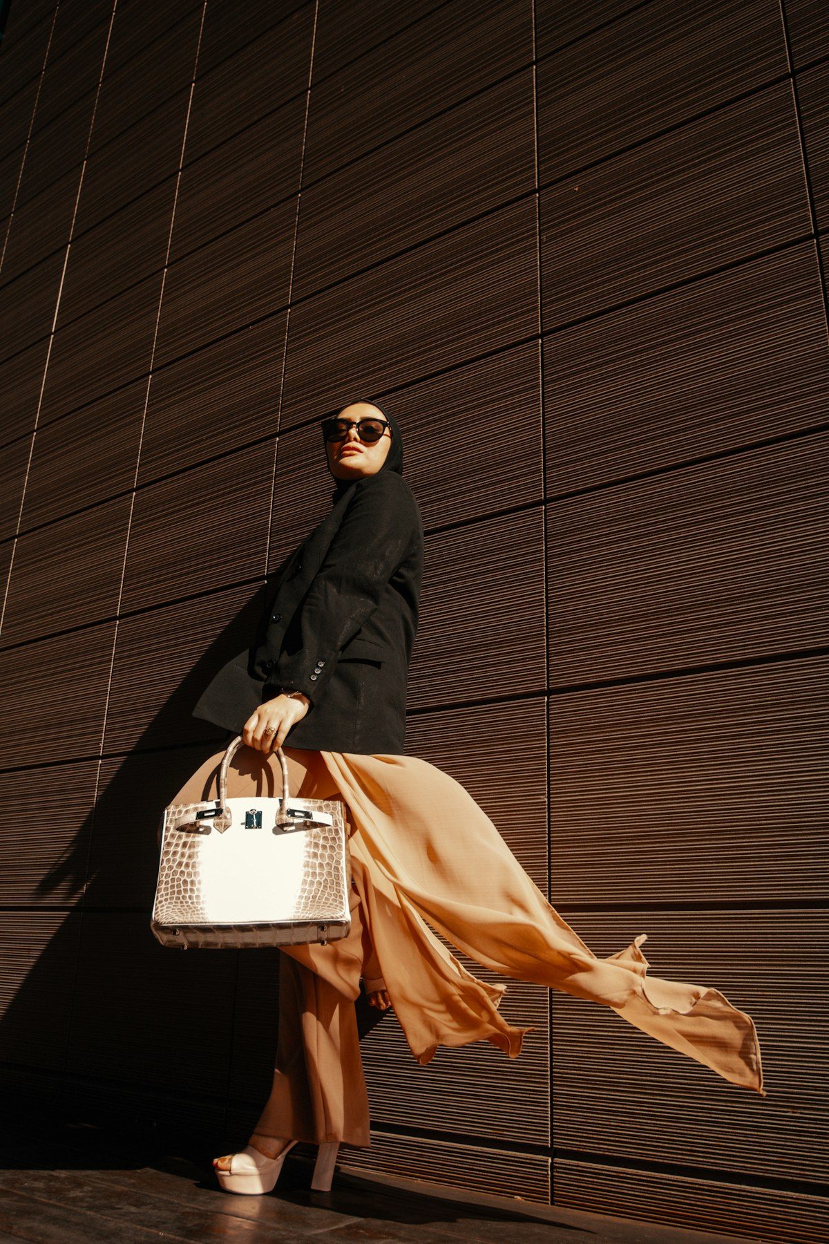 Woman in black with a white designer handbag